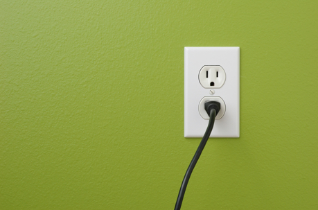 an electrical outlet on green wall