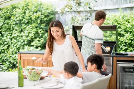 family dining at an outdoor kitchen patio